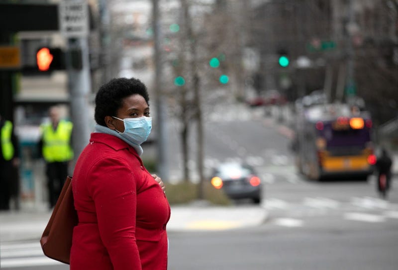 A masked pedestrian pauses near the Amazon headquarters on March 10, 2020 in downtown Seattle, Washington.