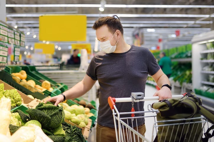 Man wearing disposable medical mask shopping in supermarket