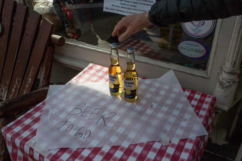 A bar serves alcohol for take out only on March 18, 2020 in the West Village neighborhood of NewYork City.
