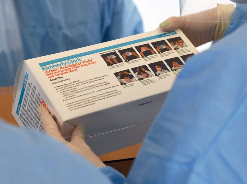 Touro University Nevada medical students check a box of N95 respirators and surgical masks.