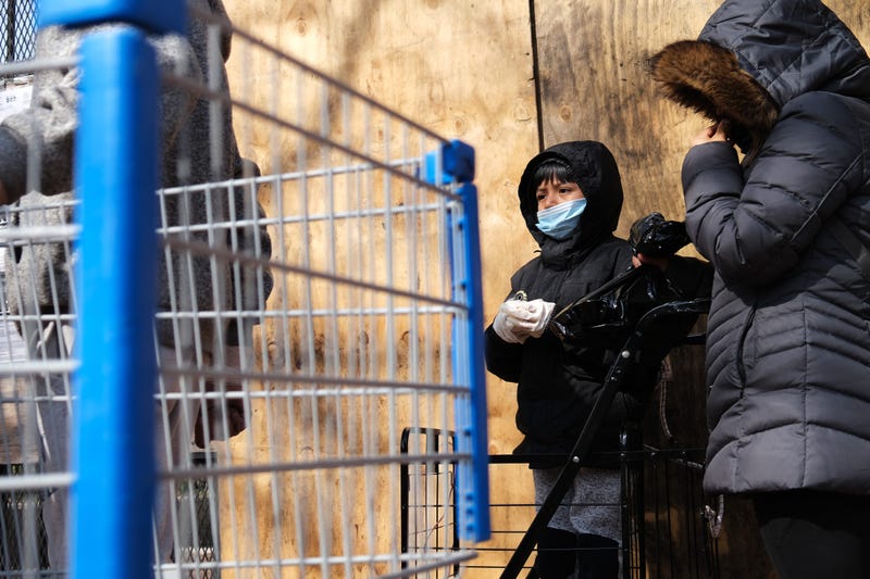 NEW YORK, NY - APRIL 07: People wait at a food distribution site that has seen a surge in demand due to the coronavirus outbreak on April 07, 2020 in the Harlem neighborhood of New York City.
