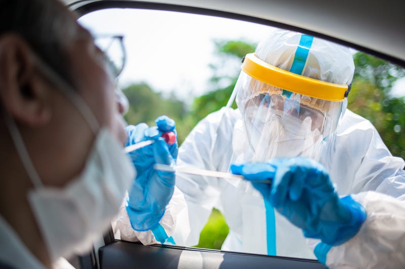 Coronavirus test - Medical worker taking a throat swab for coronavirus sample from a potentially infected elder man with the isolation gown or protective suits and surgical face masks