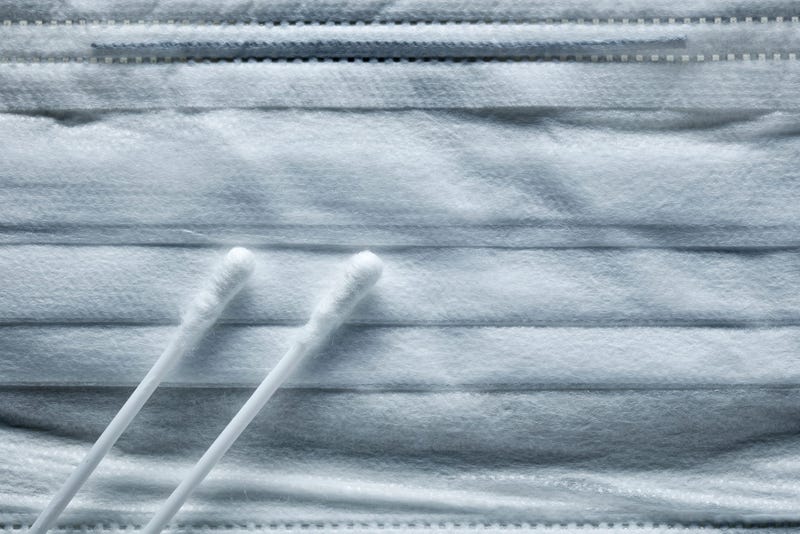 a medical mask and cotton swabs for a virus test