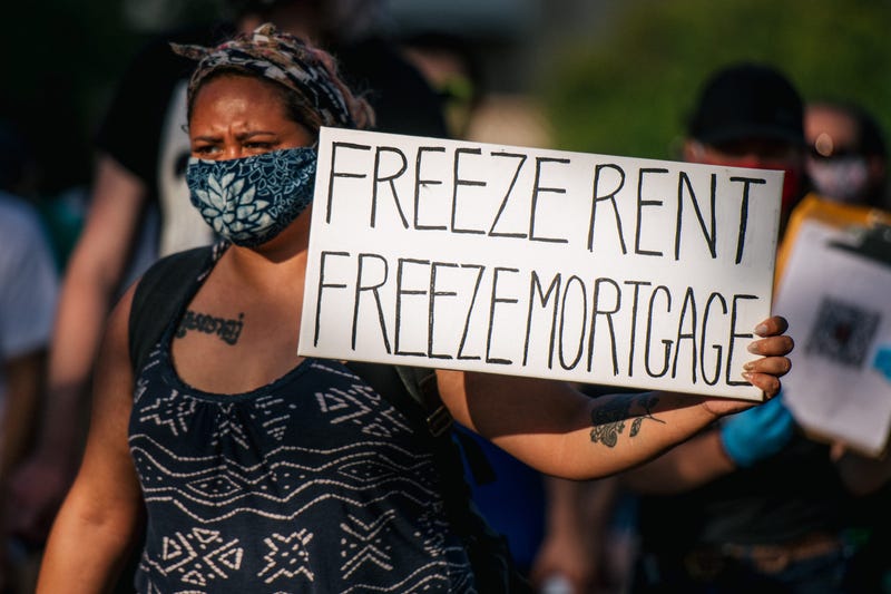 A woman holds a sign up as demonstrators march in the street during the Cancel Rent and Mortgages rally on June 30, 2020 in Minneapolis, Minnesota.