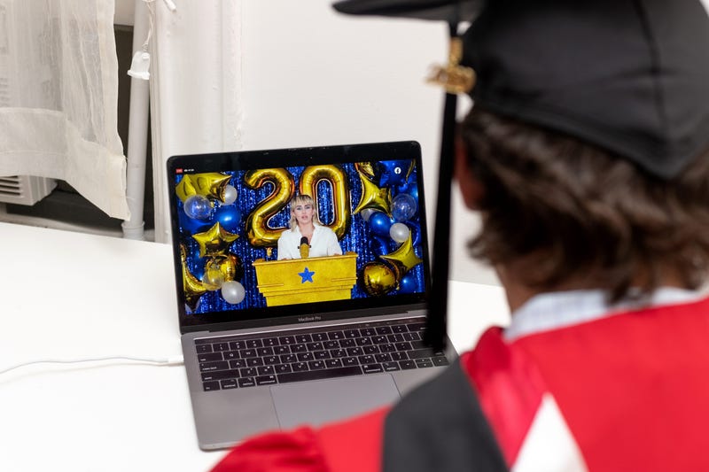A recent graduate watches Miley Cyrus perform during a virtual graduation ceremony held by Facebook from his laptop on May 15, 2020 in New York City.
