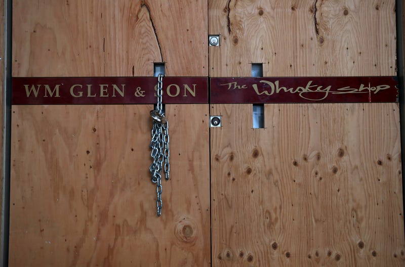 Plywood and a chain lock covers the front door of the Wm Glen & Son store on May 15, 2020 in San Francisco, California.