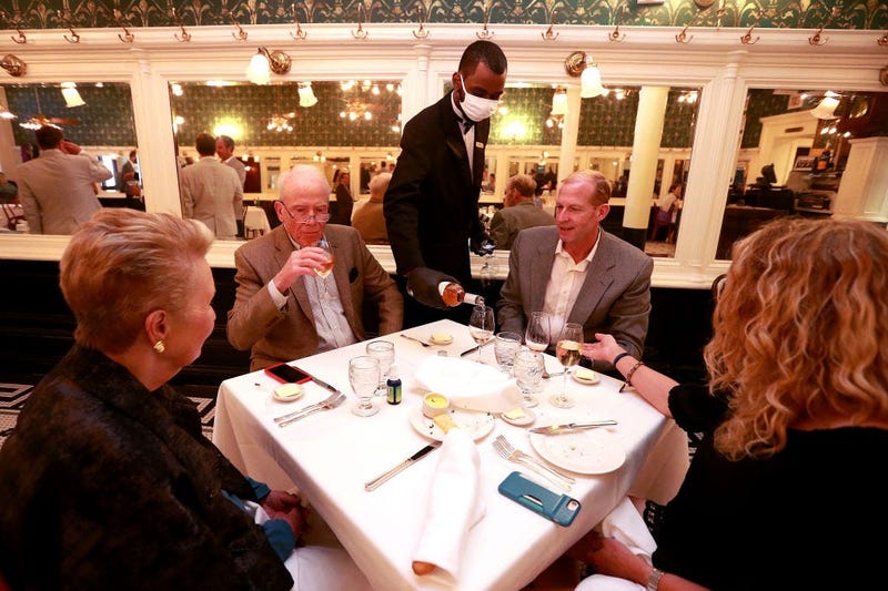A waiter pours wine during dinner at Galatoire's Restaurant on May 22, 2020 in New Orleans, Louisiana.
