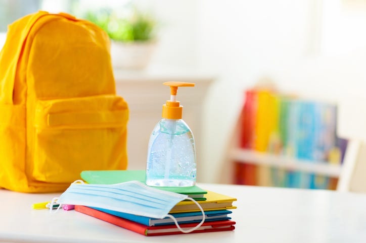 Backpack of school child with face mask and sanitizer.