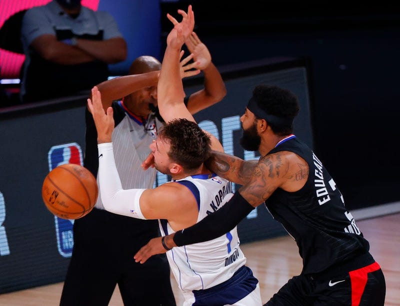 Marcus Morris Sr. #31 of the LA Clippers fouls Luka Doncic #77 of the Dallas Mavericks during the first quarter in Game Six of the Western Conference First Round during the 2020 NBA Playoffs at AdventHealth Arena at ESPN Wide World Of Sports Complex.