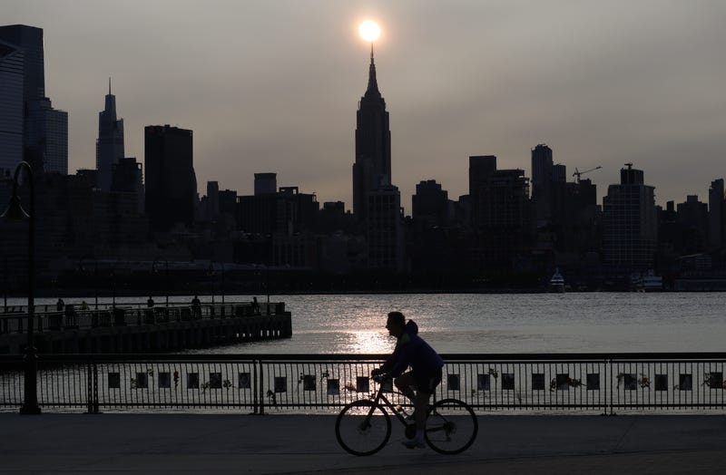 The sun rises behind the Empire State Building in New York City in a haze created by smoke from the west coast wildfires reaching the east coast of the USA on September 15, 2020 as seen from Hoboken, New Jersey.