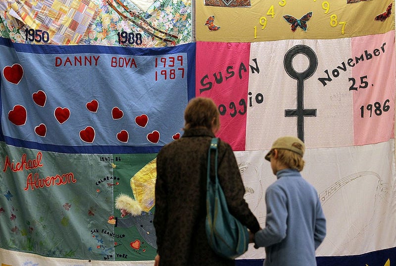 Visitors look at panels of the AIDS Memorial Quilt that are being displayed on February 13, 2012 in San Francisco, California.