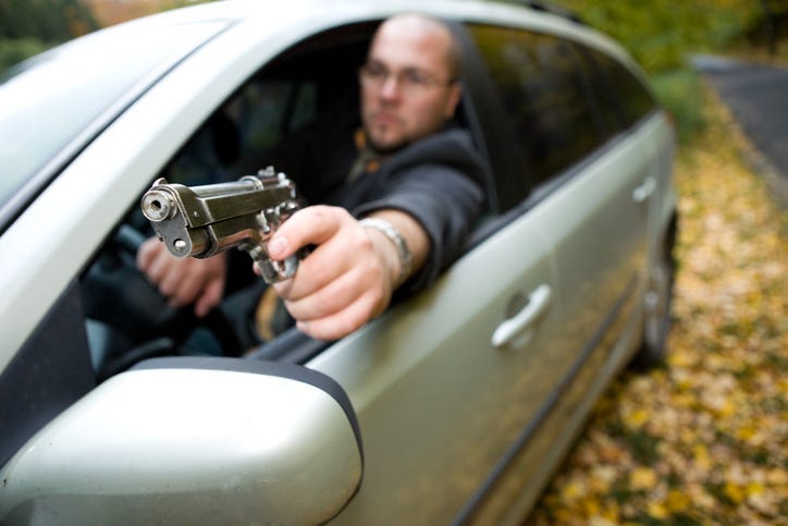 angry man with gun driving car
