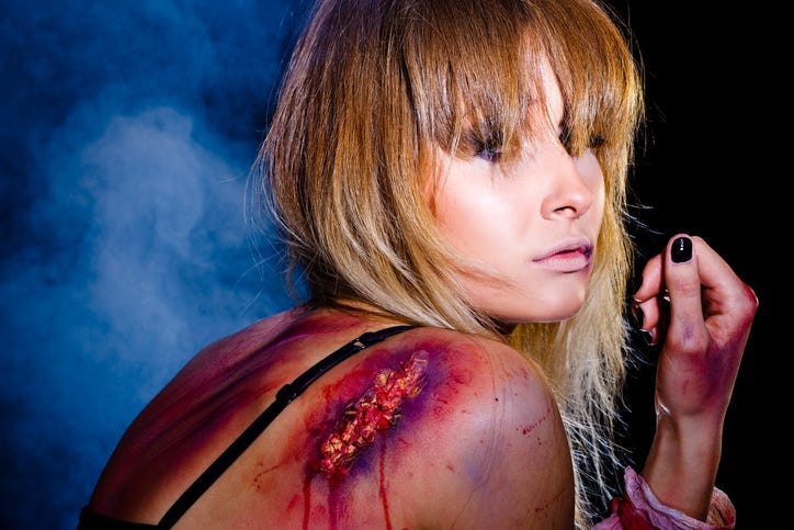 Bruised and wounded woman who survived after a tough fight; studio shot