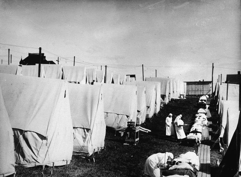 Nurses care for victims of a Spanish influenza epidemic outdoors amidst canvas tents during an outdoor fresh air cure, Lawrence, Massachusetts, 1918.