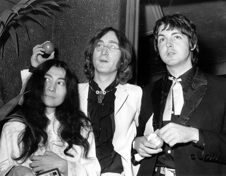 Beatle John Lennon (1940 - 1980) and his Japanese girlfriend Yoko Ono with Beatle Paul McCartney, right, at the premiere of the new Beatles film 'Yellow Submarine' at the London Pavilion. John and Paul hold apples, the symbol of their newly formed company