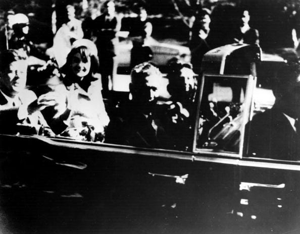 President John F. Kennedy (1917 - 1963) and his wife Jacqueline Kennedy ride with secret agents in an open car motorcade shortly before the president was assassinated in Dallas, Texas, November 22, 1963.