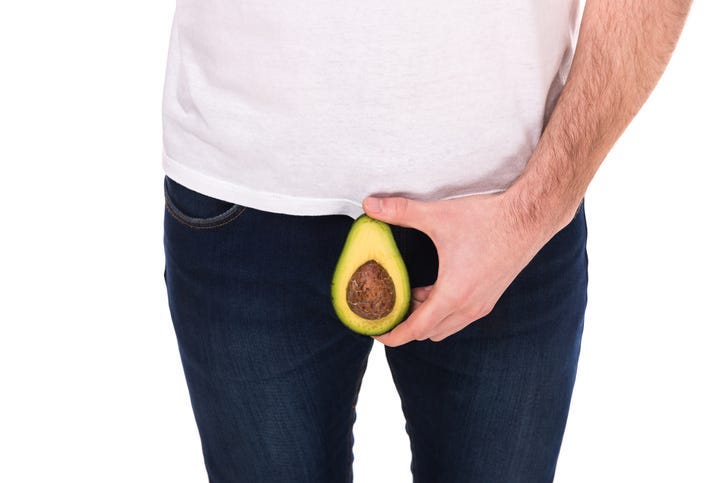 Man is holding avocado, isolated on white background.