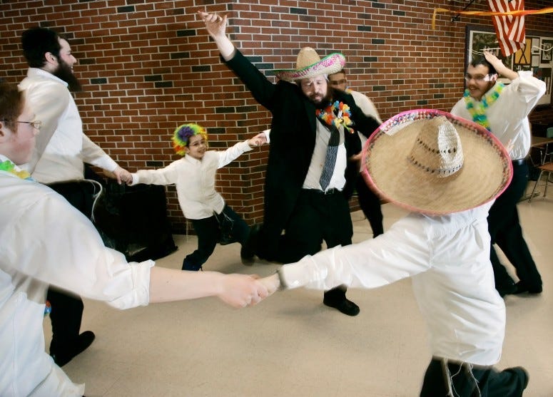 Rabbi Moshe Wilansky of Portland, center, dances with others during a Purim celebration held by Chabad of Maine at Deering High School in Portland, 2007.