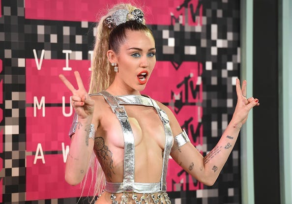 Host Miley Cyrus, styled by Simone Harouche, wearing a custom Versace outfit and boots, attends the 2015 MTV Video Music Awards at Microsoft Theater on August 30, 2015 in Los Angeles, California.