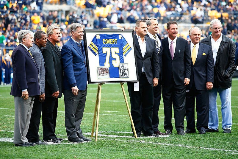 Former Pittsburgh Panthers player Jimbo Covert is surrounded by his former teammates after having his number retired at halftime between the Pittsburgh Panthers