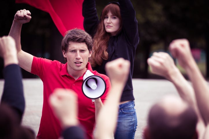 Image of young rebellious man with megaphone during street protest