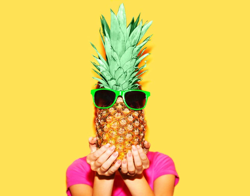 Fashion portrait woman and pineapple with sunglasses over colorful yellow