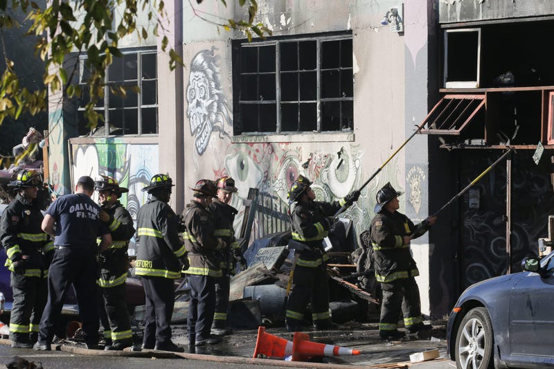 Firefighters work to clear debris at the site of the Ghost Ship warehouse in Oakland where 36 people died in a fire in 2016.