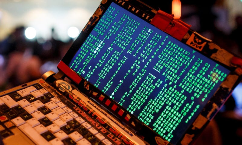A participant poses with his laptop during the 33rd Chaos Communication Congress.