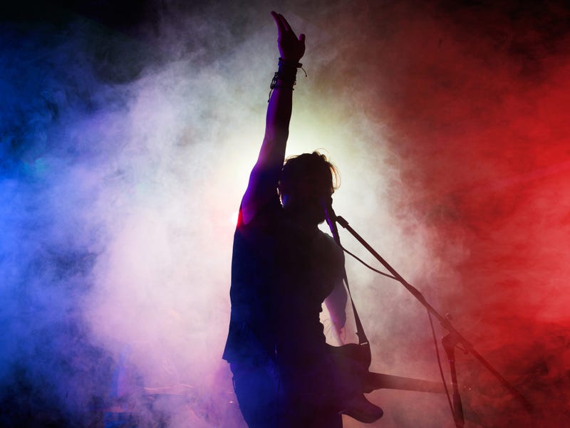 Silhouette of man playing guitar with smoky background