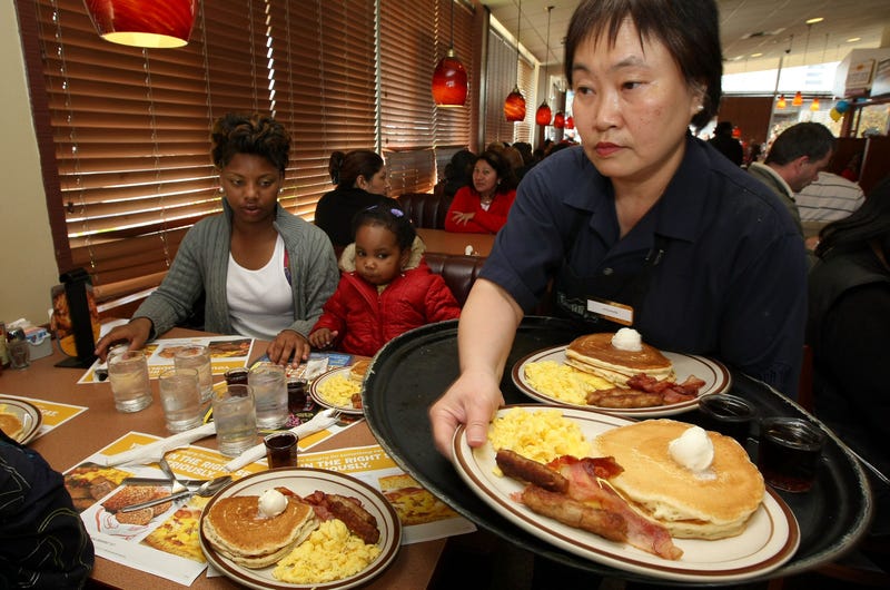 Denny's waitress Fong Van Luben (R) delivers free Grand Slam breakfasts to customers February 3, 2009 in Emeryville, California.