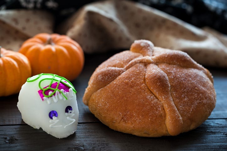 Dia De Los Muertos (Day of the Dead) Sugar Skull ( Calaverita) and bread of Dead Offering, on wooden table, selective focus