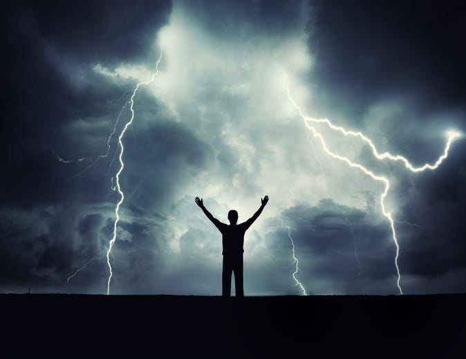 A man silhouette on a storm background. Lord of the lightning. Background on the theme of survival, religion, philosophy, psychology.