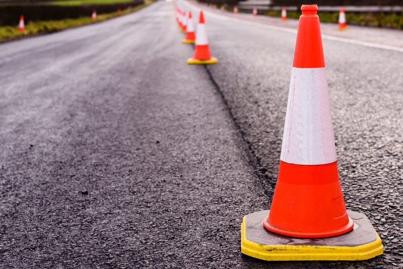 Row of traffic cones along the middle of a road being resurfaced