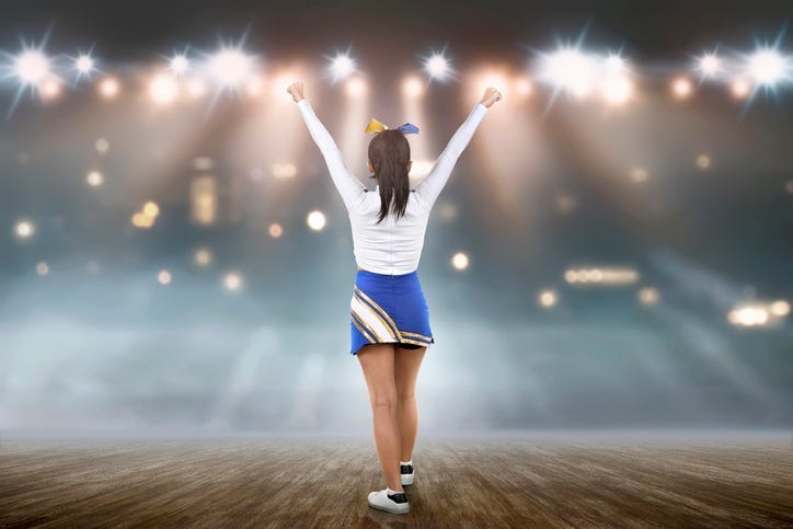 ear view of asian cheerleader in white and blue suit on the stage