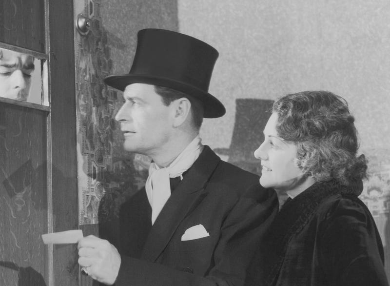 1920s man and woman stand at the door of a speakeasy bar