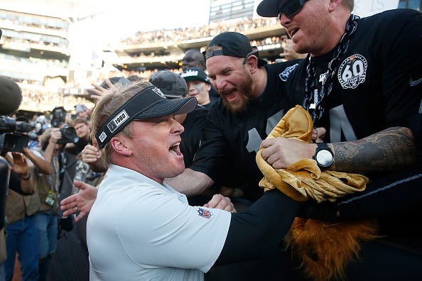 Jon Gruden celebrates a victory with Raiders fan.