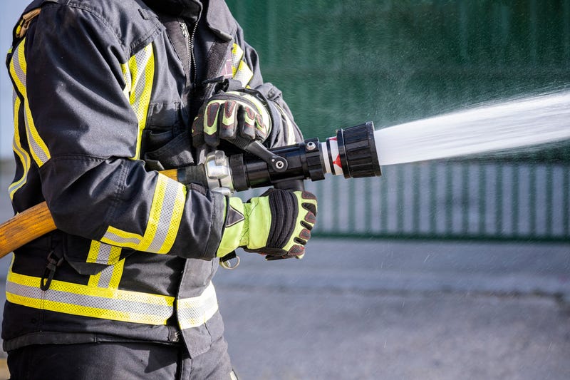 Firefighter uses water hose to fight a blaze