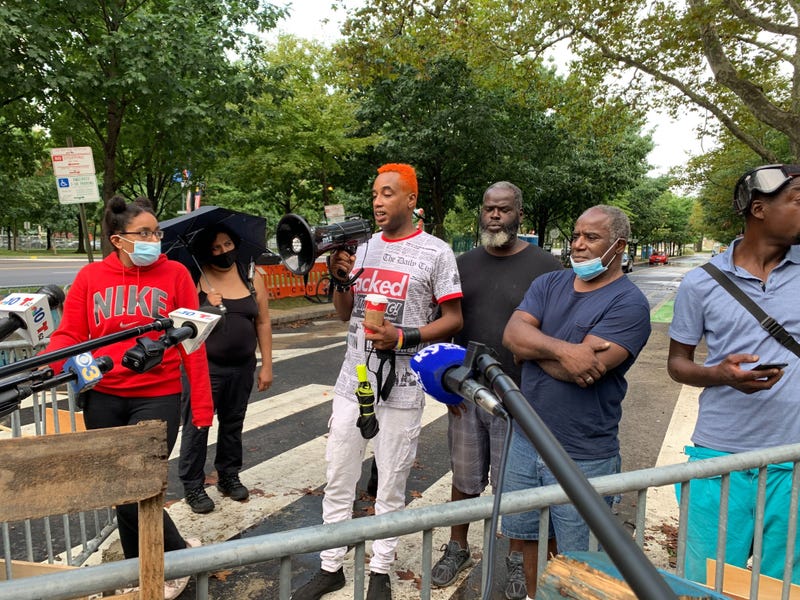 Jamaal Henderson speaks to reporters outside the protest encampment at 22nd and the Benjamin Franklin Parkway.