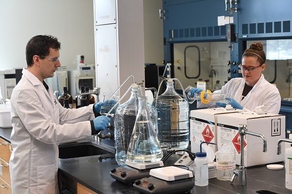 Rowan University chemistry professor Jim Grinias and his wife Kaitlin, a chemist at a pharmaceutical company, produced buckets of hand sanitizer that Rowan donated to Cooper Medical School.