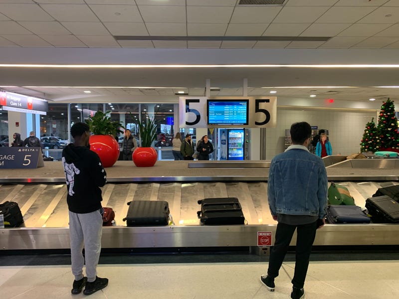 Travelers wait by the baggage claim at Philadelphia International Airport.