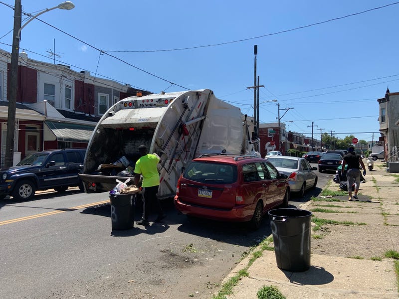 A sanitation truck collects trash near 58th and Arch Streets in West Philadelphia.