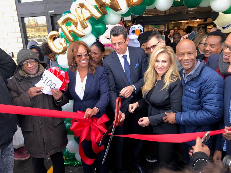 The owners of Local Market, Eva and Cezar Jakubowski cut a ribbon Wednesday opening the new store, located at 71st and Jeffery, as hundreds waited outside in the cold - some for many hours for free groceries.