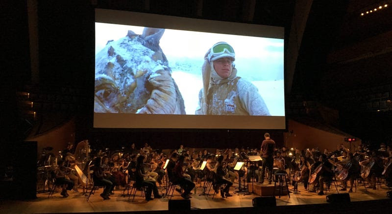 Kansas City Symphony rehearses as Empire Strikes Back plays on movie screen above them