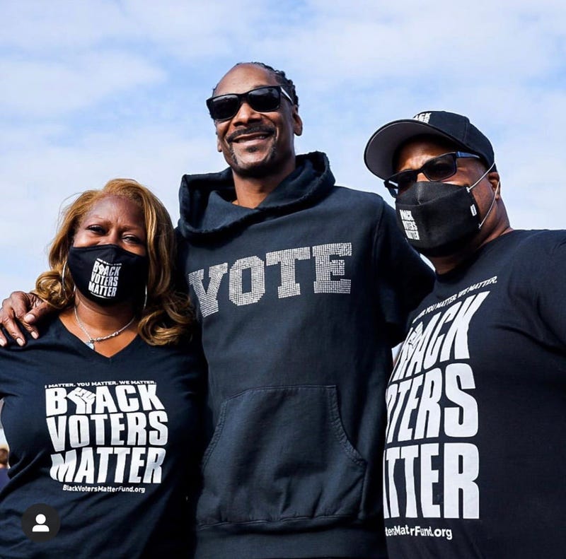 Black Voters Matter Fund co-founders LaTosha Brown (l) and Cliff Albright (r) with Snoop Dogg during a recent voter registration even in California