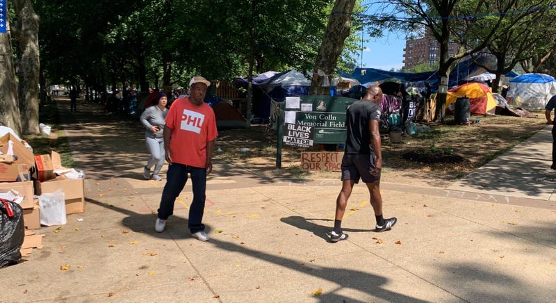 The tent encampment at Von Colln Field on the Benjamin Franklin Parkway doubles as a protest for homeless rights, but neighbors have raised concerns over sanitation.