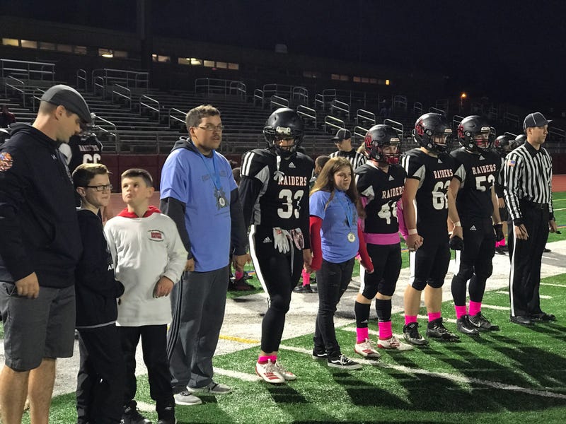 Alivia Sciarra standing alongside members of the Archbishop Ryan High School football team. Sciarra, who has special needs, got to be an honorary captain, and was named honorary homecoming queen as well.