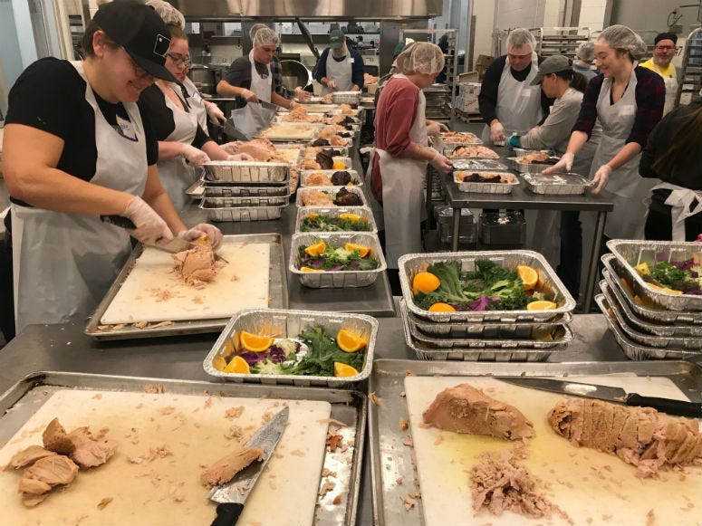 Volunteers making food in the kitchen at Metropolitan Area Neighborhood Nutrition Alliance.