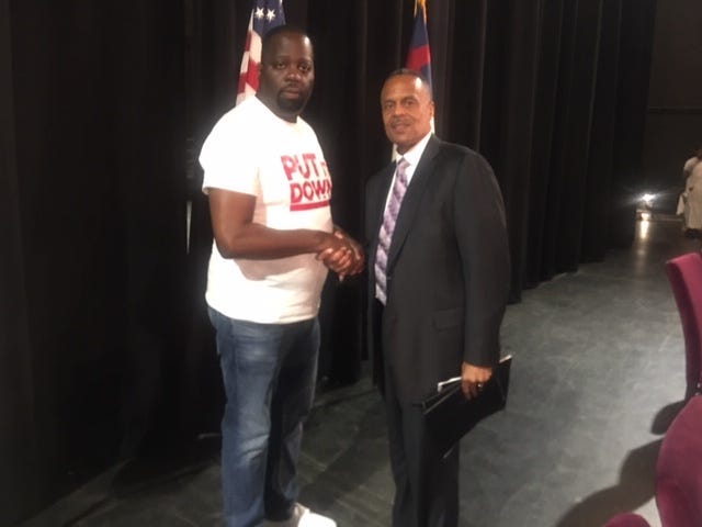 Community activist Darryl Shuler shakes hands with Philadelphia Police Commissioner Richard Ross.