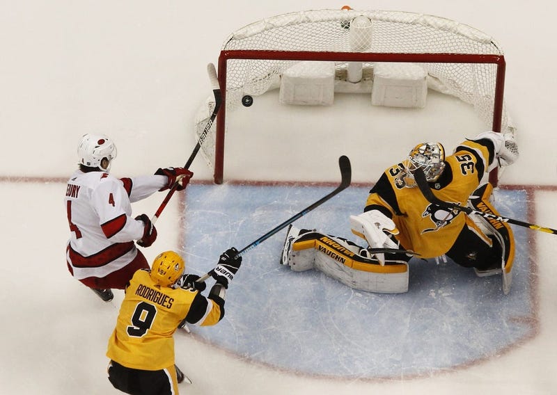 Carolina Hurricanes defenseman Haydn Fleury (4) attempts to tip the puck past Pittsburgh Penguins goaltender Tristan Jarry (35) as Pens center Evan Rodrigues (9) defends during the second period at PP...