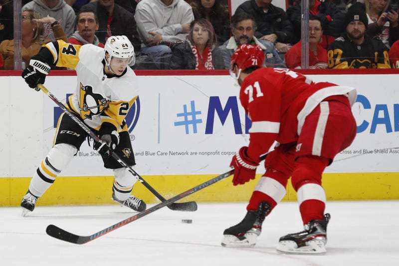 Pittsburgh Penguins center Dominik Kahun (24) skates with the puck defended by Detroit Red Wings center Dylan Larkin (71) in the third period at Little Caesars Arena.